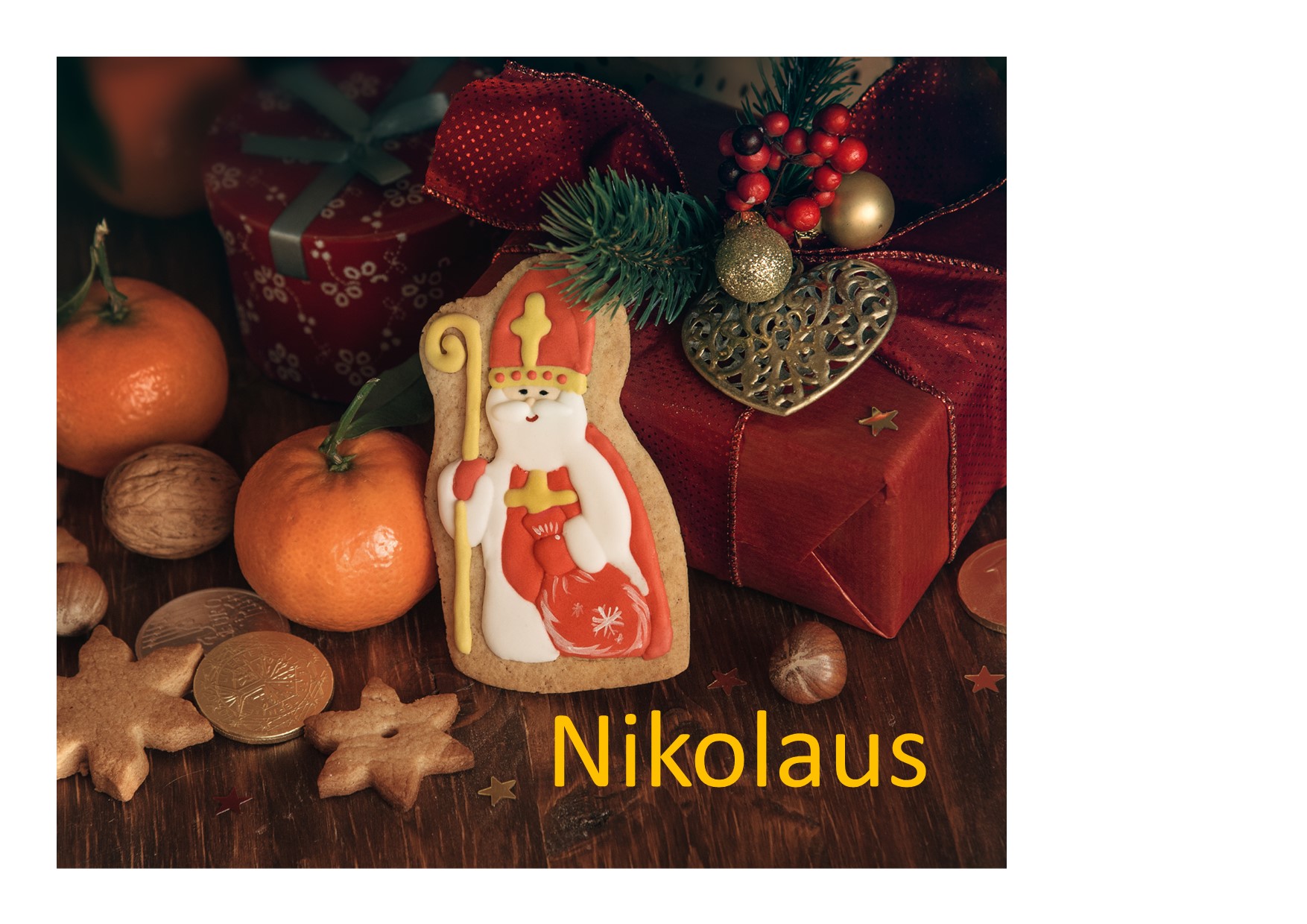 Nikolaus-Keks mit Nüssen, Orangen, Geschenken und dem gelben Schriftzug ‚Nikolaus‘